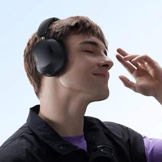 Person wearing black headphones with a clear blue sky background