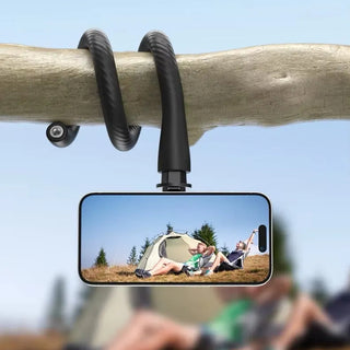 Phone holder attached to a tree branch with a scenic view of a tent and people on a phone screen.