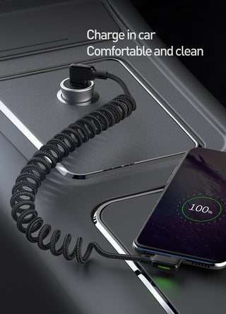 Phone charging cable connected to a car's charging port with a phone displaying a full battery charge.