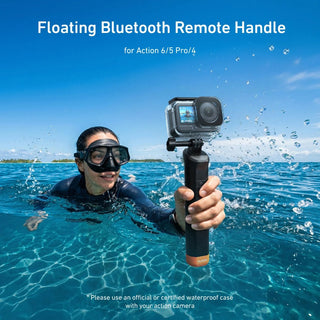 A person wearing a snorkel mask swims in clear blue ocean water while holding a floating black and orange Bluetooth remote handle attached to a camera. White text at the top reads 'Floating Bluetooth Remote Handle for Action 6/5 Pro/4' and small text at the bottom mentions a waterproof case.
