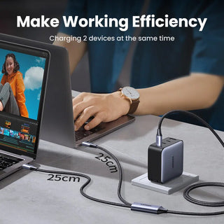 Person using a laptop with a charging adapter on a desk, emphasizing working efficiency.